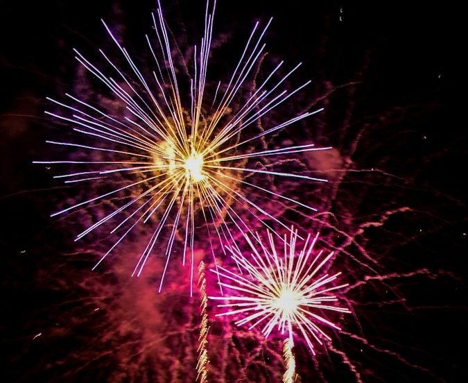a large fireworks display with a castle in the background