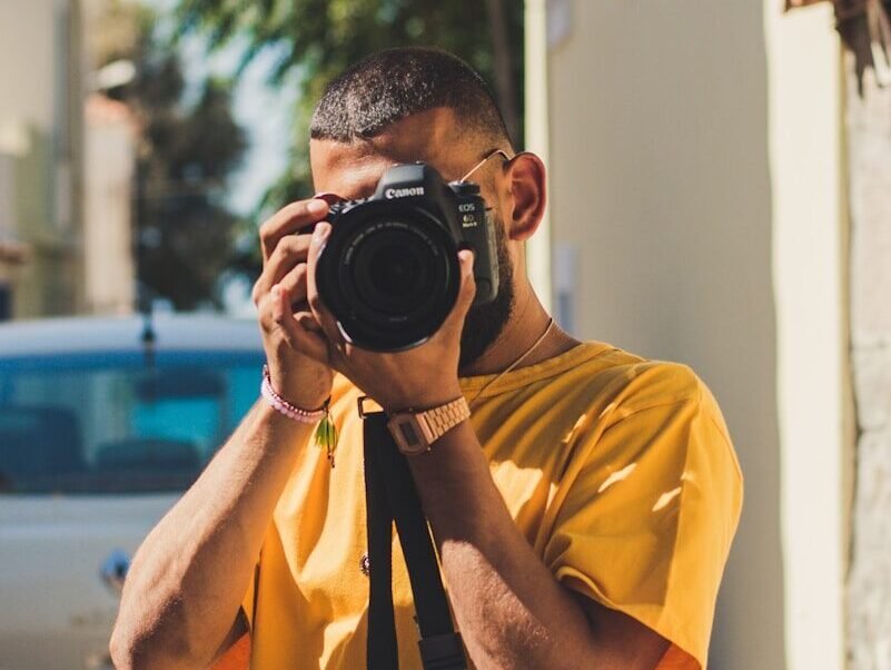 person holding black DSLR camera