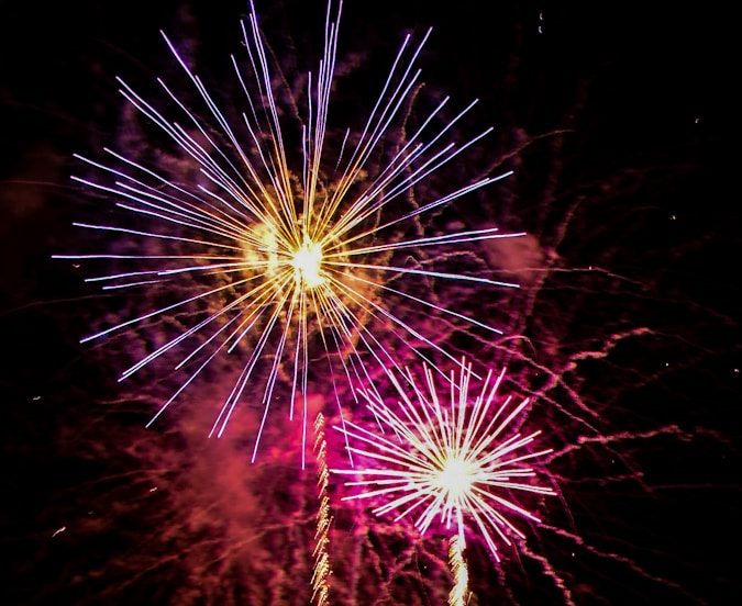 a large fireworks display with a castle in the background