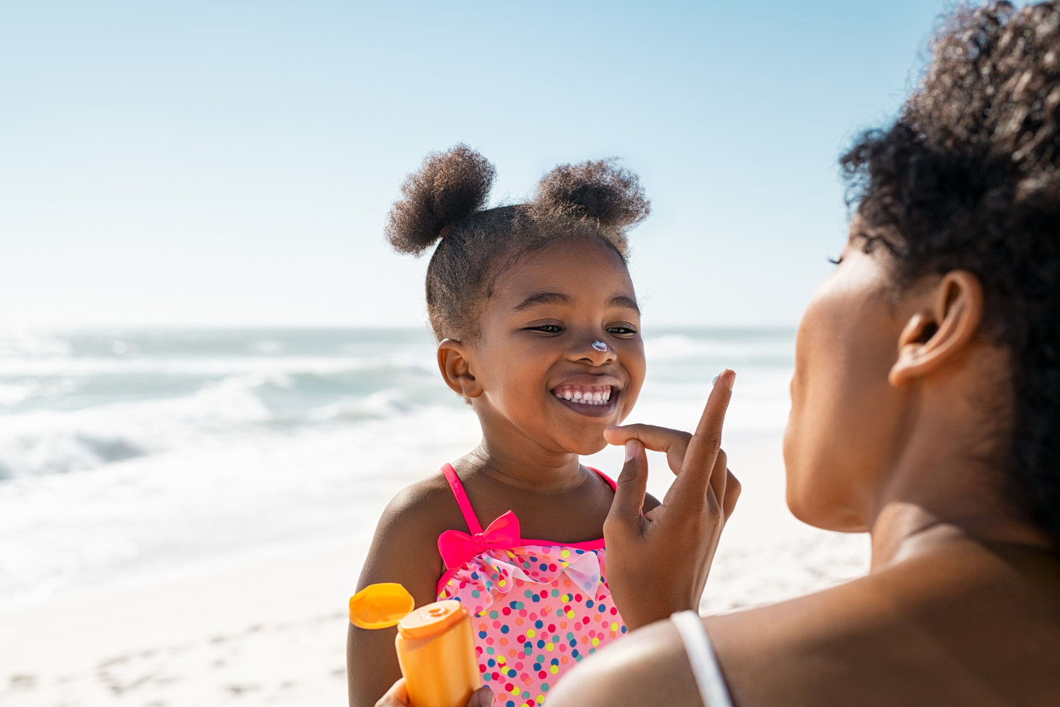 lovely black mother applying sunscreen on cute lit 2023 11 27 04 51 13 utc 1